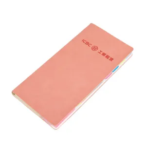 Pink sticky notes notebook with colorful index tabs, office stationery memo pad supply.