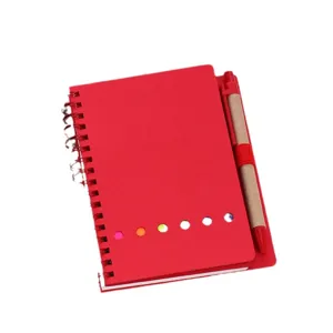 Carnet a spirale rouge avec stylo et notes adhesives, ideal pour le bureau et l'ecole.