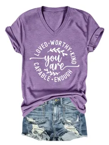 Close-up van paarse V-hals korte mouw t-shirt met inspirerende print en spijkerbroek short.
