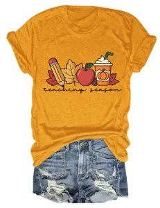 Close-up detail of yellow short sleeve t-shirt featuring teacher season graphic design.