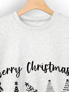 Close-up detail of grey women's sweatshirt featuring Merry Christmas text and tree print.