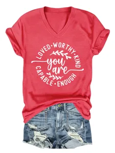 Detailopname van het rode V-hals t-shirt met witte tekstprint gecombineerd met een korte broek.
