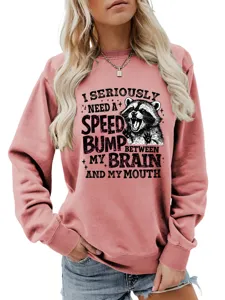 Nahaufnahme des witzigen Waschbär-Grafikdrucks und Spruchs auf dem rosa Sweatshirt.