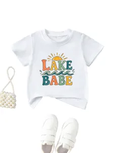 Detail shot of white kids t-shirt featuring colorful lake babe sun graphic and soft fabric.