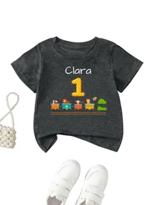 Dettaglio della maglietta grigia per bambini con nome Clara e trenino di animali.