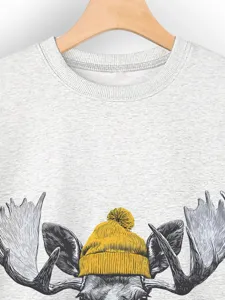Detalle de la sudadera gris de mujer con bonito diseño de alce y gorro amarillo.