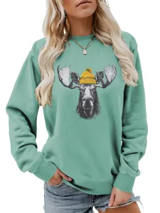 Detalle de sudadera verde menta para mujer con bonito gráfico de alce y gorro amarillo.