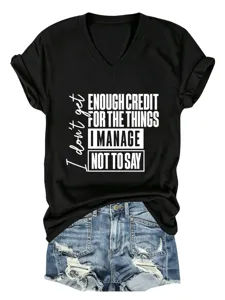 Λεπτομέρεια από κοντομάνικο μαύρο t-shirt με V λαιμόκοψη, εκτύπωση κειμένου και τζιν σορτς.