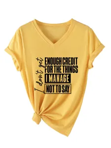 Λεπτομέλεια κίτρινου t-shirt λαιμόκοψη V κοντομάνικο με σύνθημα και κόμπο στο τελείωμα.