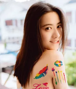 Primer plano de pegatina de tatuaje temporal colorido con diseño de pluma de arco iris.