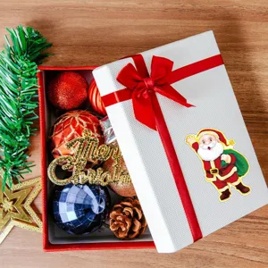 Christmas gift box set with festive ornaments, Santa Claus sticker and decorative items for holiday.