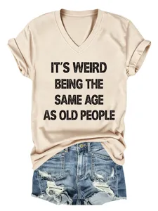 Λεπτομερής όψη του casual μπεζ T-shirt με V λαιμόκοψη και αστείο τυπωμένο σλόγκαν.