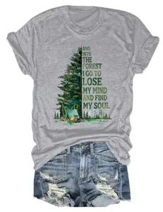 Vista dettagliata di una t-shirt grigia con grafica da campeggio nel bosco e testo ispiratore.
