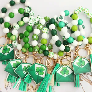 St. Patricks Day beaded keychain with green shamrock wooden beads and tassel charms.