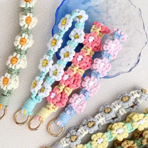 Handmade woven daisy phone lanyard wrist strap, cute floral charm keychain accessory.