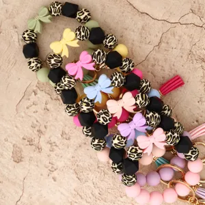Silicone beaded keychain detail, featuring colorful leopard print spheres, bows and tassels.