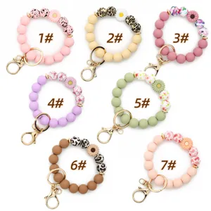 Silicone beaded wristlet keychain with cute daisy flower charms and metal clasp for keys.