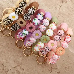 Close-up detail of vibrant silicone beaded keychains with floral charms and leopard print.