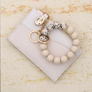 White leather card holder with beaded wristlet keychain, multi-card slot zipper wallet.