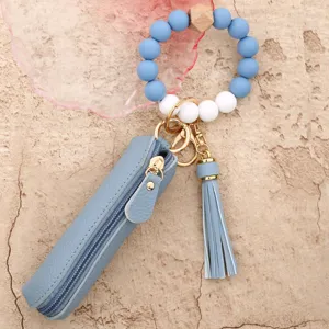 Silicone bead wristlet keychain detail with blue leather pouch and matching tassel charm.