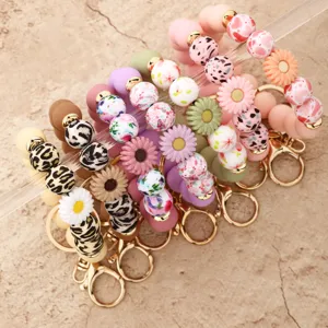 Silicone beaded keychain detail view featuring cute floral and leopard print design charms.