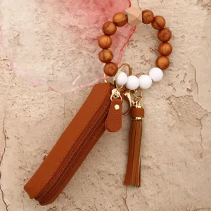 Silicone beaded wristlet keychain with brown leather lipstick pouch and tassel charm for women.