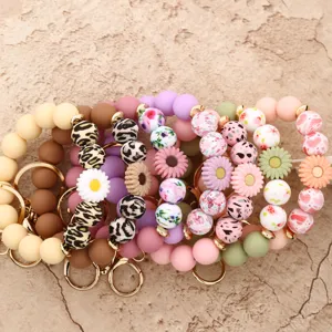 Silicone beaded wristlet keychain detail featuring cute daisy flowers and leopard print styles.
