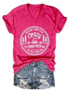 Women pink V-neck short sleeve t-shirt with camp graphic print paired with denim shorts.