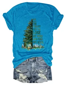 Primo piano di una t-shirt blu a maniche corte con grafica da campeggio nella foresta.