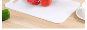 Thick plastic cutting board for kitchen use, durable chopping block with ergonomic handle design.