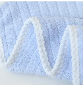 Close-up detail of soft fluffy blue and white striped kids face towel texture showing plush fabric.
