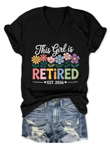 Vista dettagliata della t-shirt nera con collo a V e maniche corte con grafica e fiori.