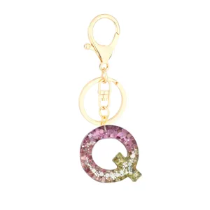 Gold metal hardware resin letter Q keychain charm with sparkling pink and green glitter.