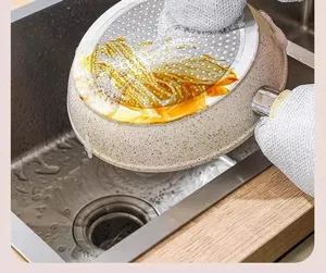 Detail shot showing waterproof steel wire cleaning gloves scrubbing kitchen pots efficiently.