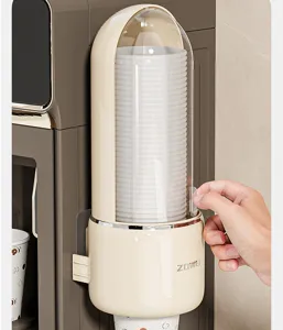 Close-up of wall-mounted disposable paper cup dispenser with clear dust-proof cover.