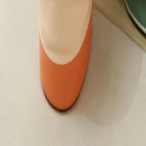 Gedetailleerd uitzicht op de onderkant van de opvouwbare voetbadkuip in oranje en beige kleur.