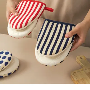 Kitchen heat-resistant oven mitts with cute striped and polka dot patterns for safe cooking.