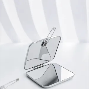 Portable folding double-sided makeup mirror with magnetic closure in sleek silver finish.