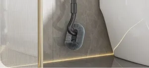 Detailed view of grey toilet brush with curved long handle and soft dense bristles for bathroom.