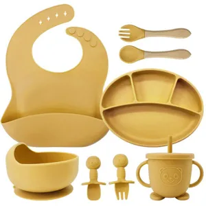 Silicone baby feeding set with divided plate, suction bowl, bib, and spoons for toddlers.