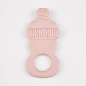 Pink silicone baby teether detail view, infant pacifier chewing toy with safe grip ring and texture.