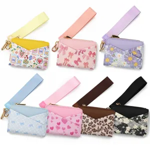 Leather card pouch with wrist strap and key ring, featuring multiple cute printed patterns.