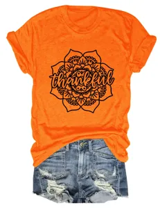 Close-up view of orange graphic t-shirt featuring mandala flower and thankful text detail.