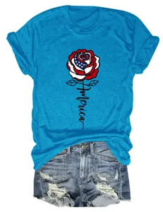 Detail shot of blue short sleeve t-shirt featuring USA flag rose graphic and script text.