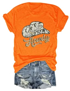 Orange short sleeve t-shirt with howdy cowboy hat graphic paired with denim shorts.