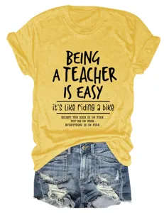Vista dettagliata di una divertente t-shirt grafica da insegnante in giallo con pantaloncini.