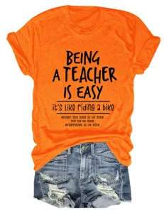 Primo piano sul dettaglio della t-shirt arancione con stampa insegnante e pantaloncini.