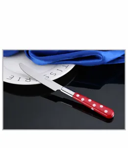 Cuchillo de cena de acero inoxidable con mango de lunares rojos, detalle pulido.