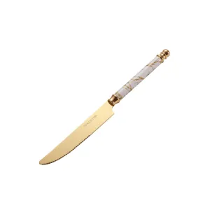 Stainless steel steak knife with gold titanium finish and elegant marble handle for table.