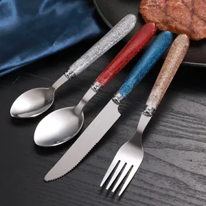 Set di posate in acciaio inossidabile con manici glitterati, forchetta, coltello e cucchiai.